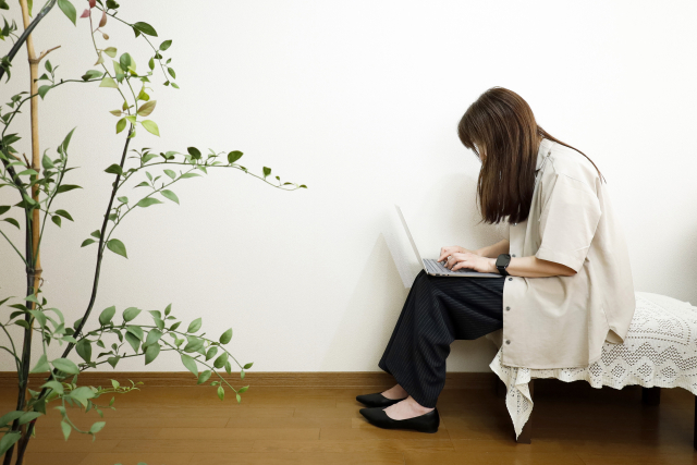 姿勢が悪い状態で仕事をしている女性