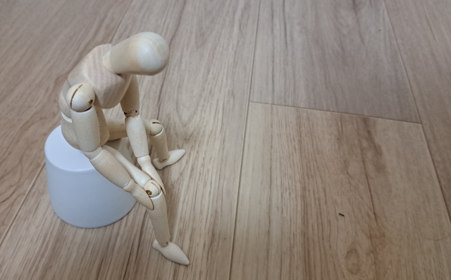 膝をおさえている人形