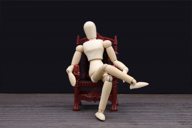 脚を組んで座っている人形